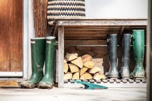 Wellington boots and logs outside a door