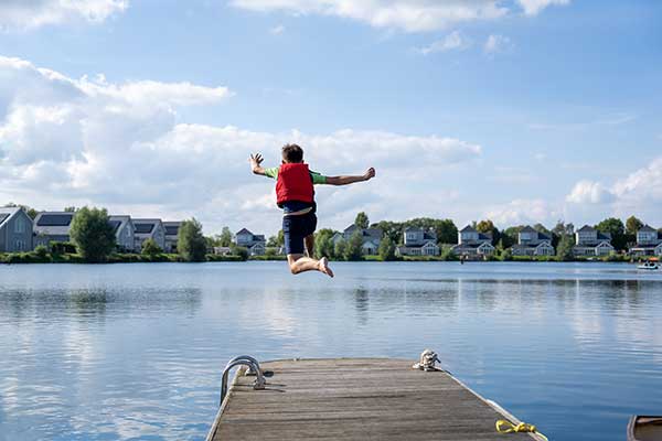 Child jumping from the pier at Meadowlark into Summer Lake