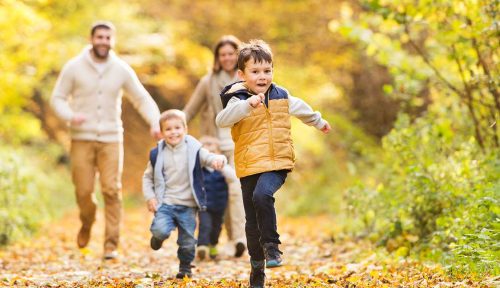 Family walking through the woods in autumn